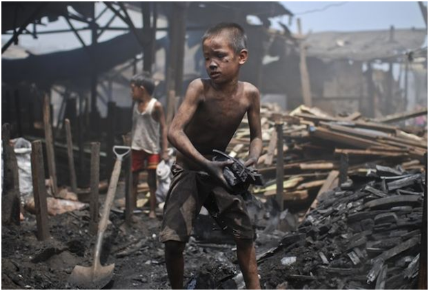 Filipino child laborers work in the charcoal dump of a port district in Manila, Philippines.